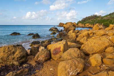 Rocks on beach against sky