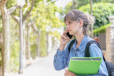 Blonde female student listening on her phone