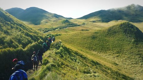 People on mountain against clear sky