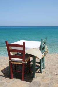 Deck chairs on beach against clear sky