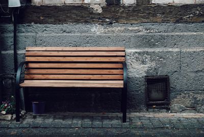 Empty bench against wall