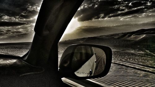 Low section of man against cloudy sky