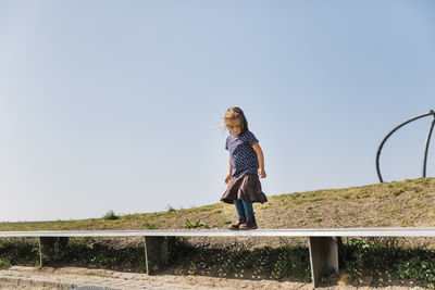 Full length of woman standing against clear sky