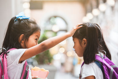 Close-up of sisters touching head of each other