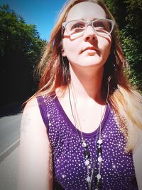 Portrait of beautiful young woman wearing sunglasses standing outdoors