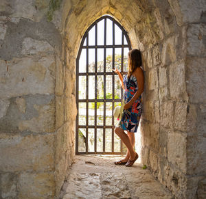 Side view of woman looking through window in castle