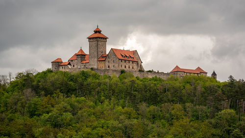 Castle on a hill against cloudy sky