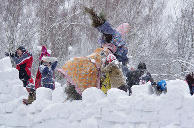 People skiing on snow covered field