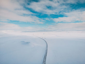 Snow covered landscape against sky