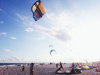 People paragliding at beach against sky