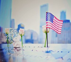 American flag by roses on table