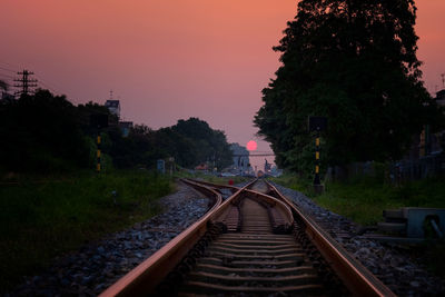 View of railroad tracks against sky at sunset