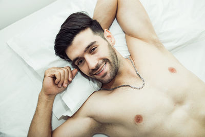 Portrait of young man lying on bed