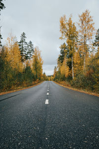 Road amidst trees against sky