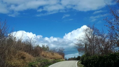 Road amidst trees against sky