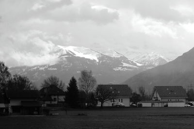 Scenic view of buildings and mountains against sky