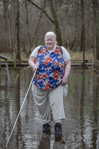 Full length of woman walking in lake against trees at forest