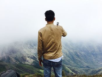 Rear view of a man overlooking rocky landscape