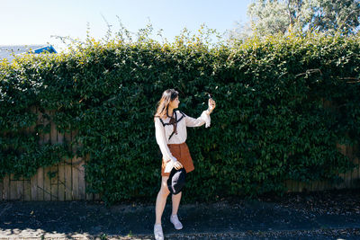 Full length of woman standing by plants