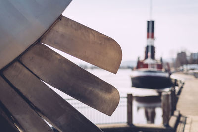 Close-up of propeller against boat moored on lake