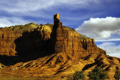 Rock formation on mountain against cloudy sky