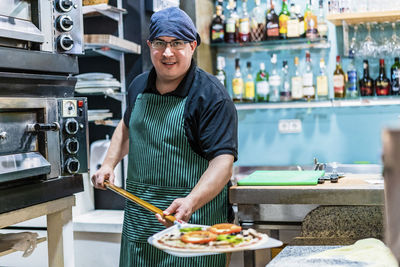 Young man preparing food in restaurant