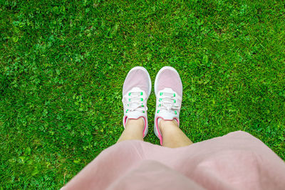 Low section of woman standing on grass