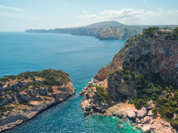 Aerial view of rock mountain by sea