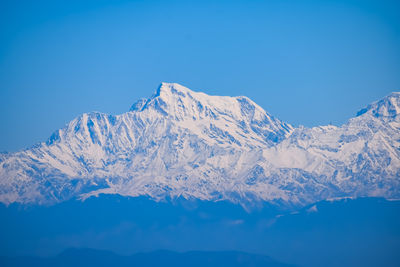 Scenic view of snowcapped mountains against clear blue sky