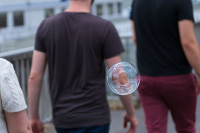 Close-up of bubble against men on street