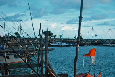 Sailboats moored in sea against sky