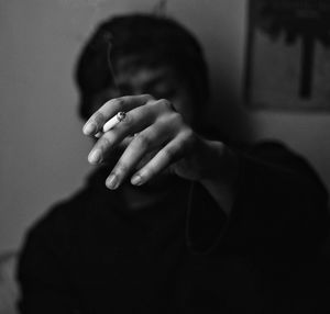 Man holding cigarette sitting in darkroom