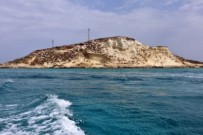 Scenic view of rocks in sea against sky