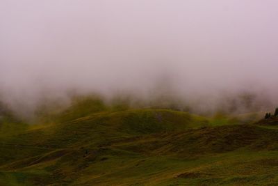 Countryside landscape against sky during foggy weather