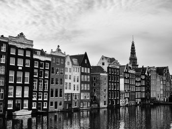 Buildings in city against cloudy sky