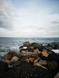 Rocks on beach against sky