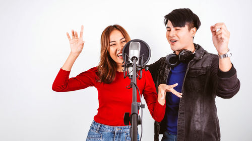 Young couple standing against white background