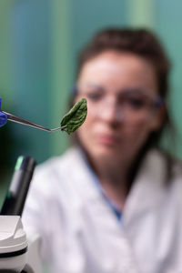 Close-up portrait of man holding leaf