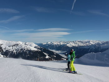 People skiing on snowcapped mountain against sky