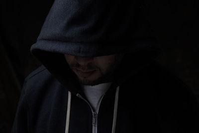 Close-up portrait of young man against black background
