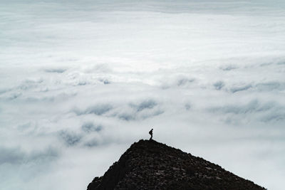 Man on rock against sky