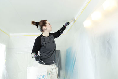 Woman painting ceiling