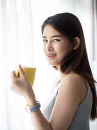Portrait of a beautiful young woman drinking glass