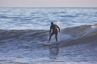 Full length of man standing in sea against sky