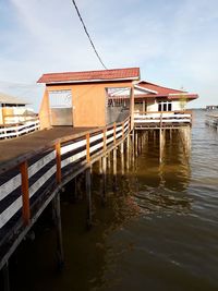 Pier over sea and buildings against sky