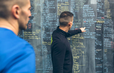 Instructor explaining over blackboard to athlete in gym