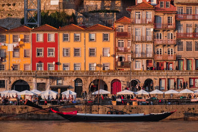 Boats moored at canal against buildings in city