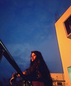 Low angle view of woman standing against built structure