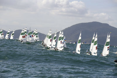 Boats sailing in sea against sky