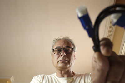 Mature man with grey hair taking a cable from a drawer at home